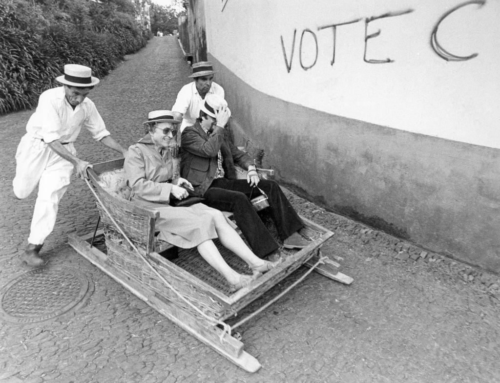 Tourists in Madeira, two Portuguese men pushing a sledge, 1971.