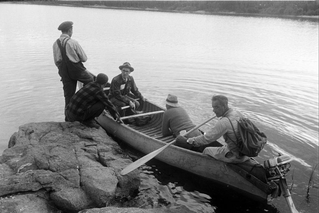People riding a boat during their search for uranium in Saskatchewan, 1930s.