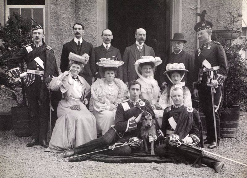 Group of 12 people outside entrance, possibly at Aikenshaw, c.1904. Titled: 'S K Turnbull, A Arrol Snr, Montagu Baird, Campbell of Cambusaskin, Franklyn Baird, A Theo Arrol, Miss Wm Arrol, Baroness V Grote, Miss G Arrol, Mr Baird'.