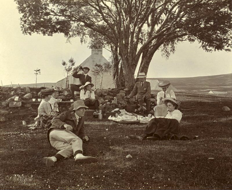 Group having picnic, 1907. Headed paper on the album page is titled 'Achernack, Grantown-on-Spey'. Photograph titled: 'I Asher, A Henderson, T Horne, E Macpherson, B Younger, M Younger, R Bruce-Clark, H J Horne'