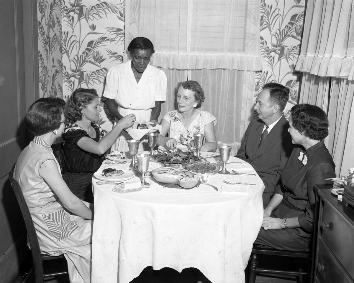 Lamar Bledsoe and others being served at a dinner party, August 1953