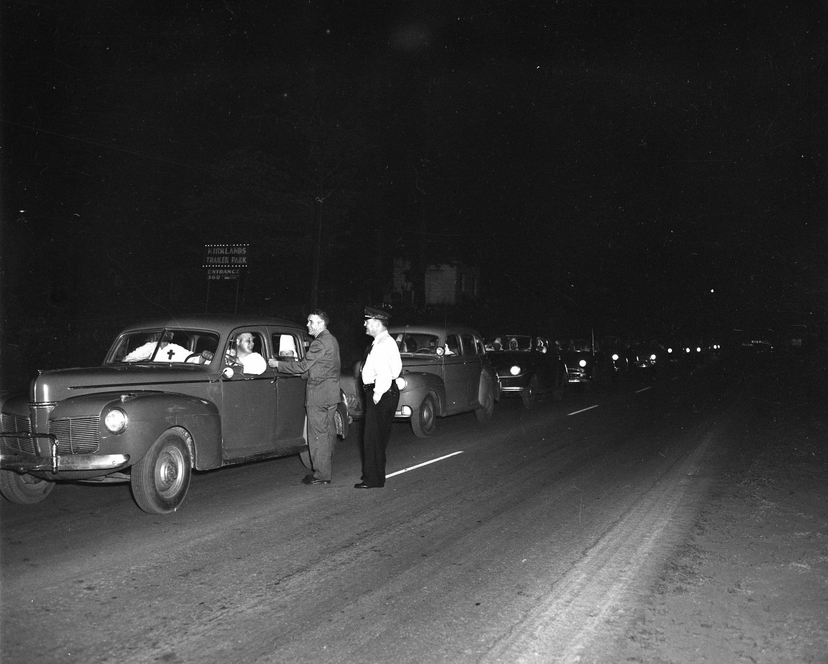 Ku Klux Klan in their cars and talking with men standing in the road, September 1, 1956