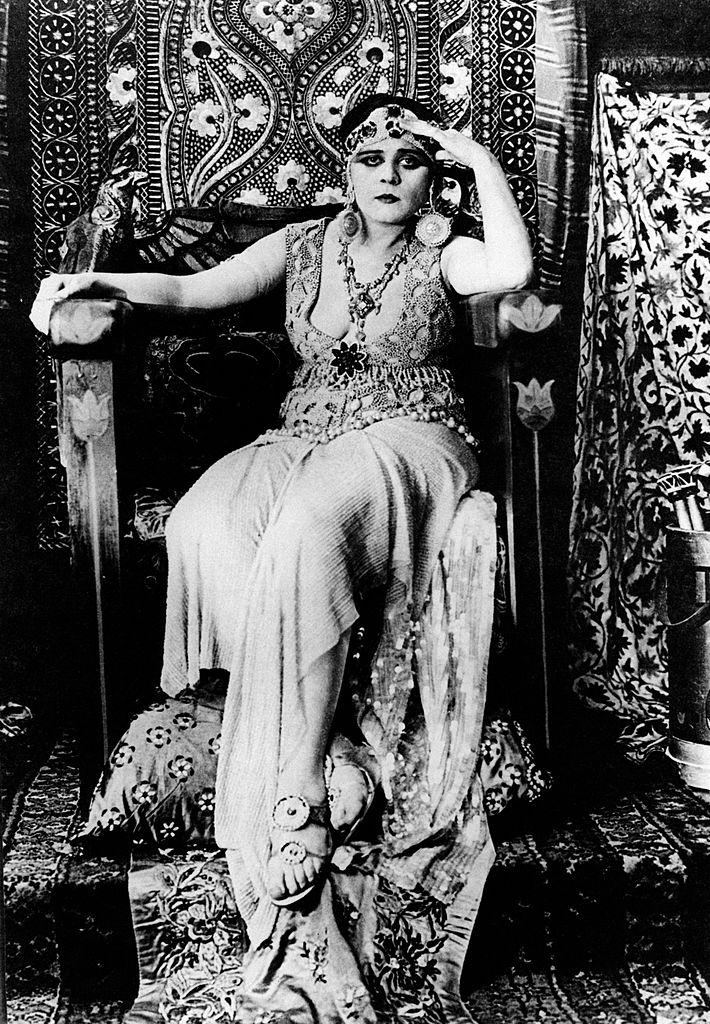 Theda Bara as Cleopatra sitting on a throne in the film Cleopatra. 1917