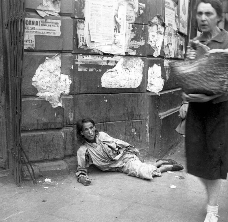 A woman lying on the pavement in the Warsaw ghetto, starving to death, 1941.
