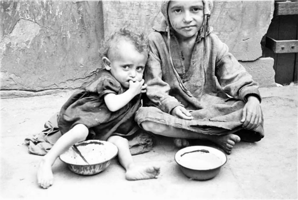 Two children begging for food on the street.
