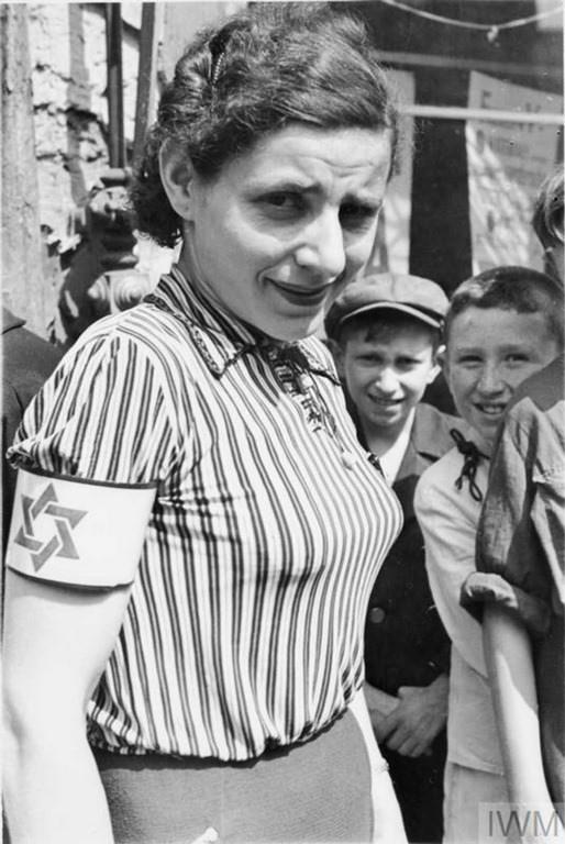 A portrait of a young woman wearing a striped blouse and an armband with the Star of David.