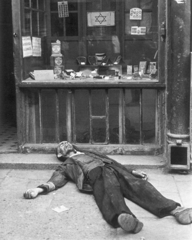 Dead man lies in front of a shop in the Warsaw ghetto.