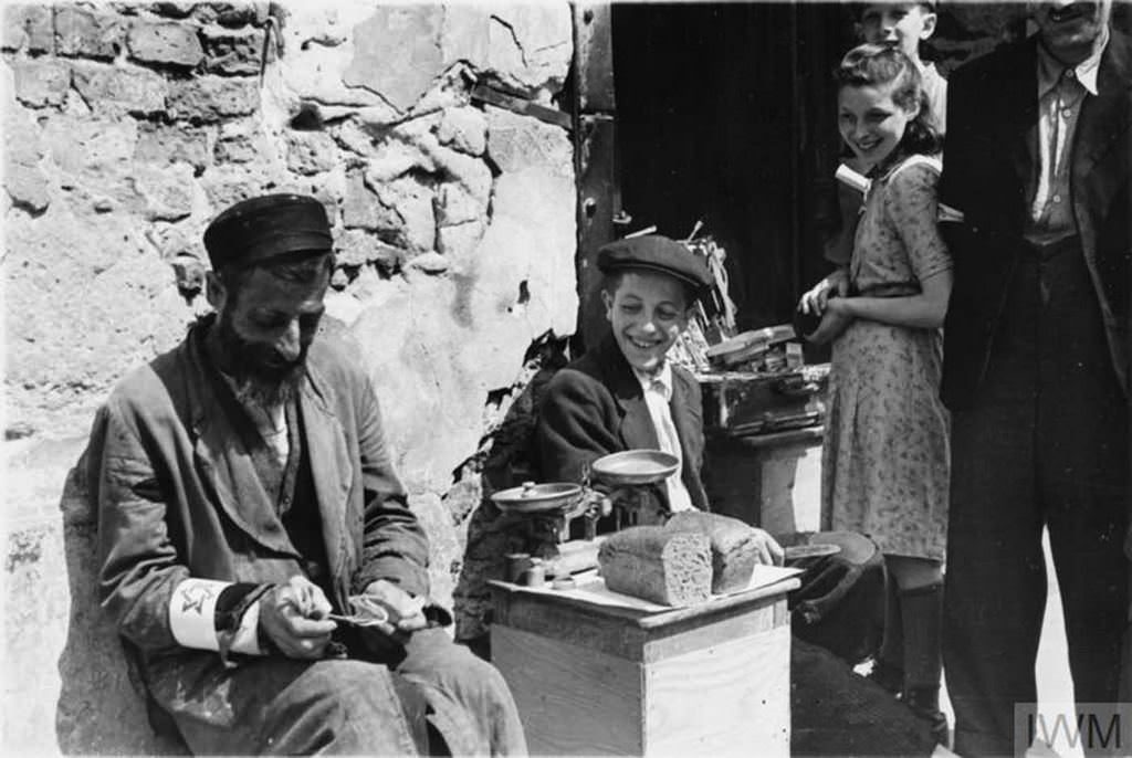 A Jewish man selling his bread allowance in the street of the ghetto, summer 1941.