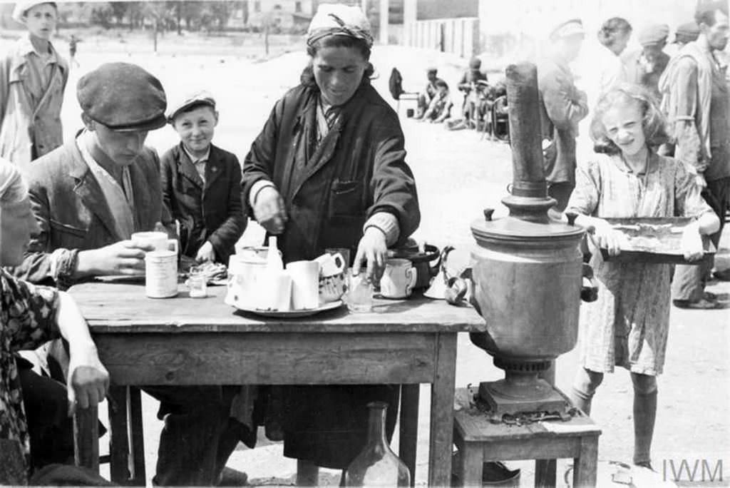 A female tea seller serving hot drinks to customers in a makeshift cafe in a street market in the ghetto.