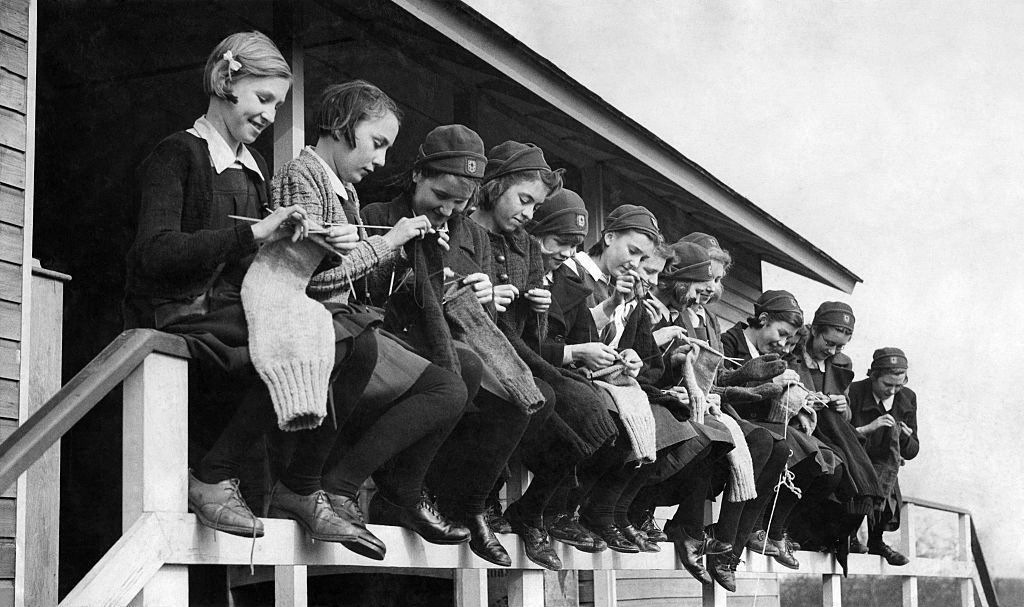 Girls at the Finnermore wood camp huts are here seen knitting sea stockings and jerseys for the crews of wartime convoys. May 1941.