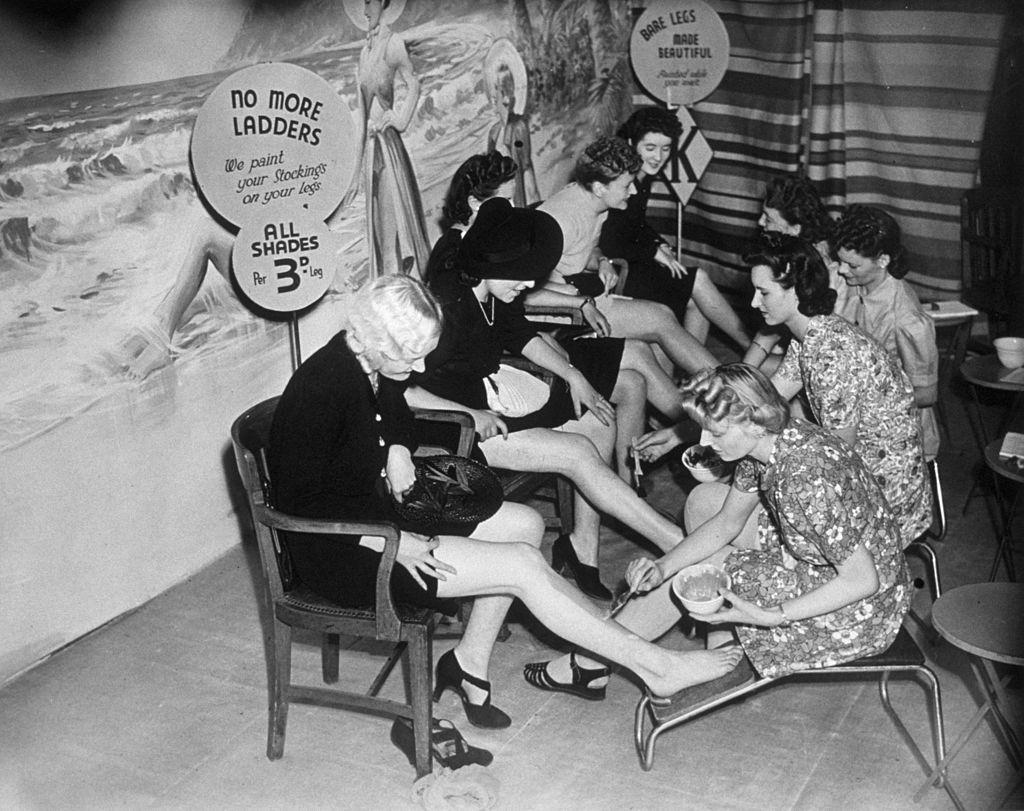 Customers have their legs painted at a store in Croydon, so they can save their coupons which would otherwise be used for stockings.