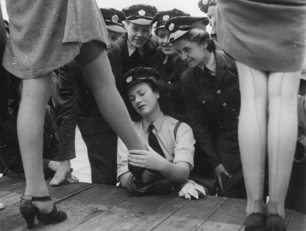Servicewomen look at a design of artificial silk-plated stocking, called 731, specially designed for servicewomen at a fashion show at Kennards of Croydon. 22nd September 1943.