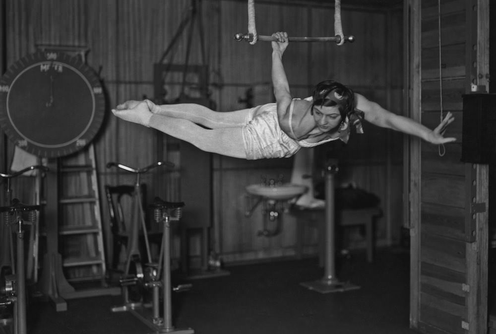 A woman using an apparatus in the gymnasium of the ocean liner S.S. Bremen.1930s
