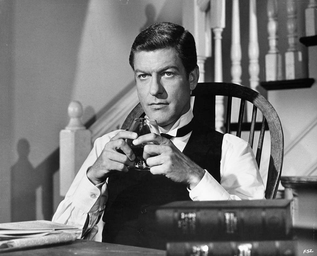 Dick Van Dyke sitting in a tuxedo holding a snifter glass in a scene from the film 'Fitzwilly', 1967.