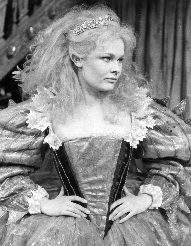 Judi Dench wearing a wig and a long ruffled gown, 1962.