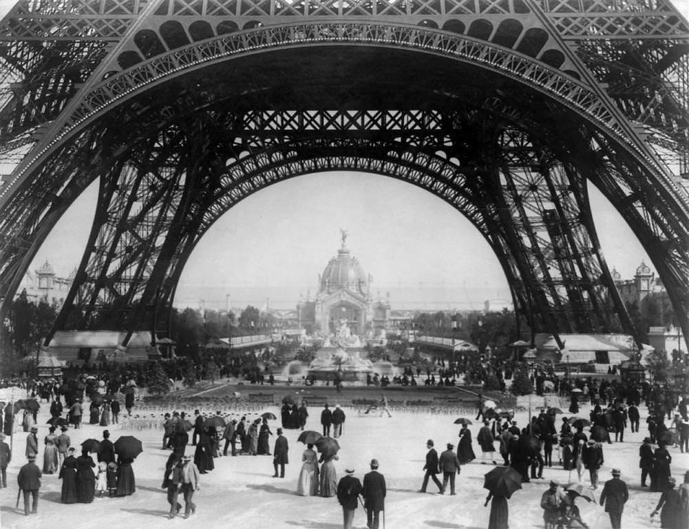 Paris Exposition, view from ground level of the Eiffel tower with Parisians promenading, 1889.