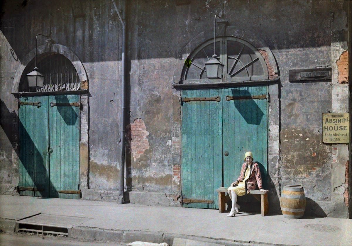 A woman sits outside the door of the Old Absinthe House in New Orleans.