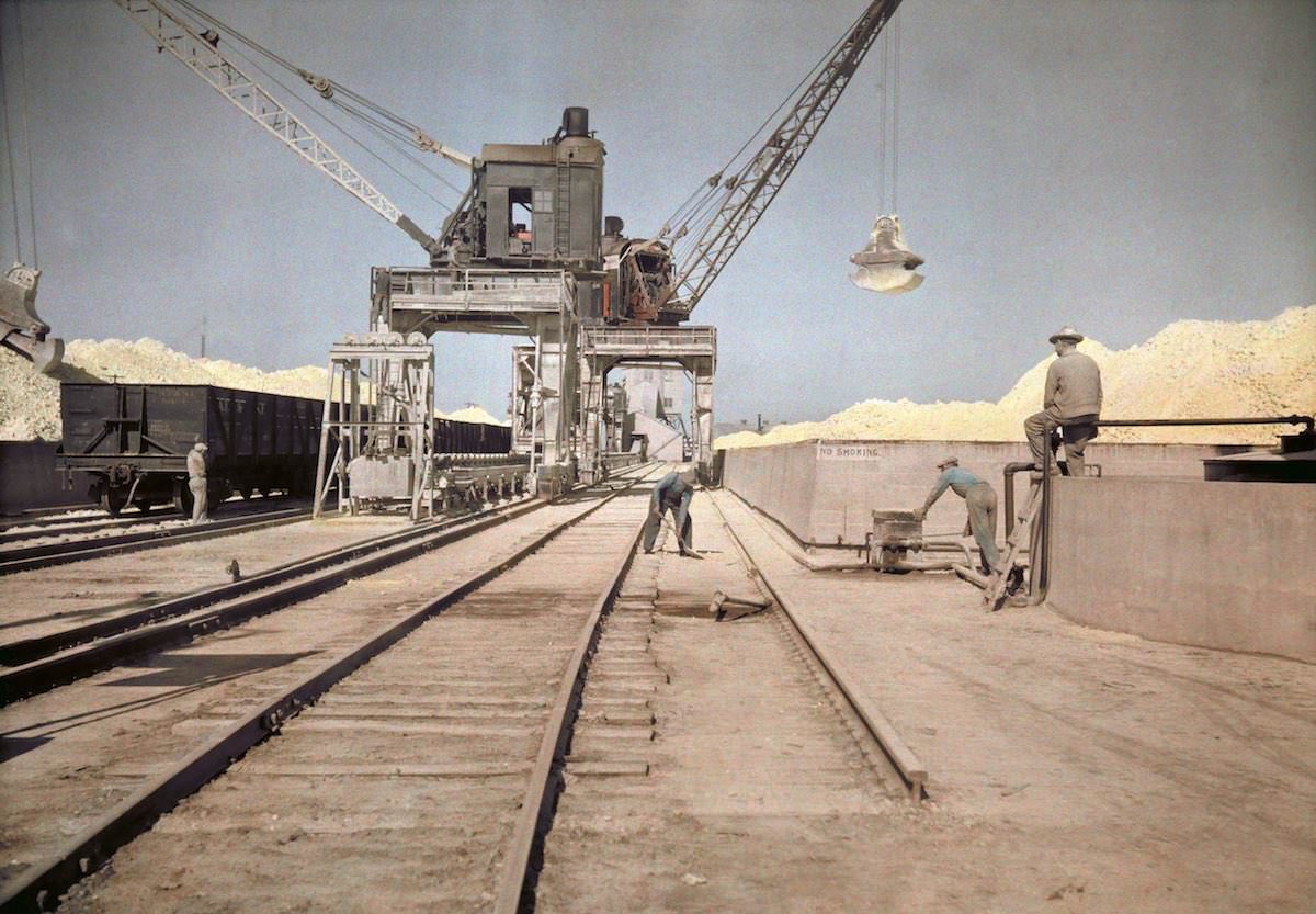 Men load bins with sulfur, Galveston, TX.