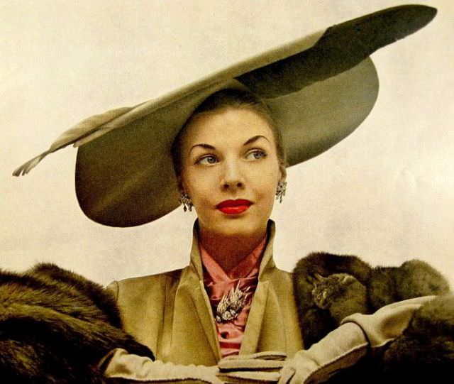 Model is wearing hat with large feather by Lilly Daché, Vogue, November 1948