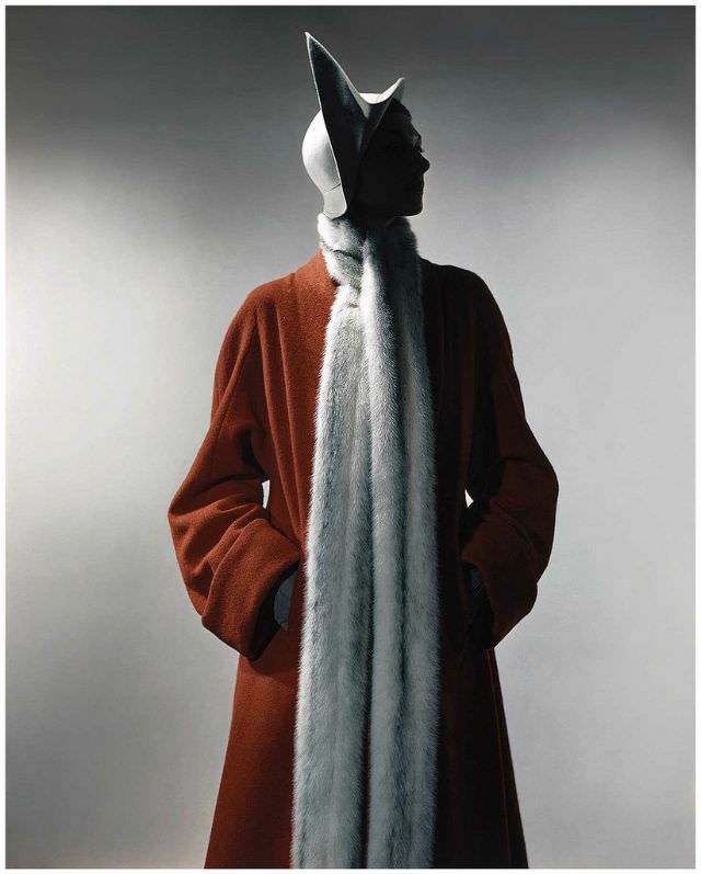 Model is wearing a free-flowing coat made of red French wool and a cream side peak cloché.