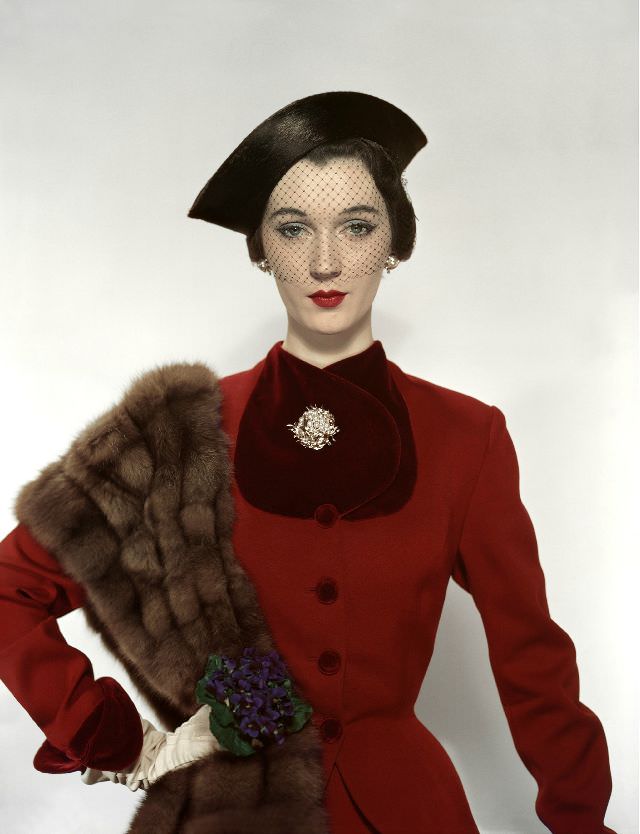 Dovima in Pacific Craft Fabric woolen suit trimmed in velvet, hat, and brooch by Verdura, Vogue, August 1, 1950