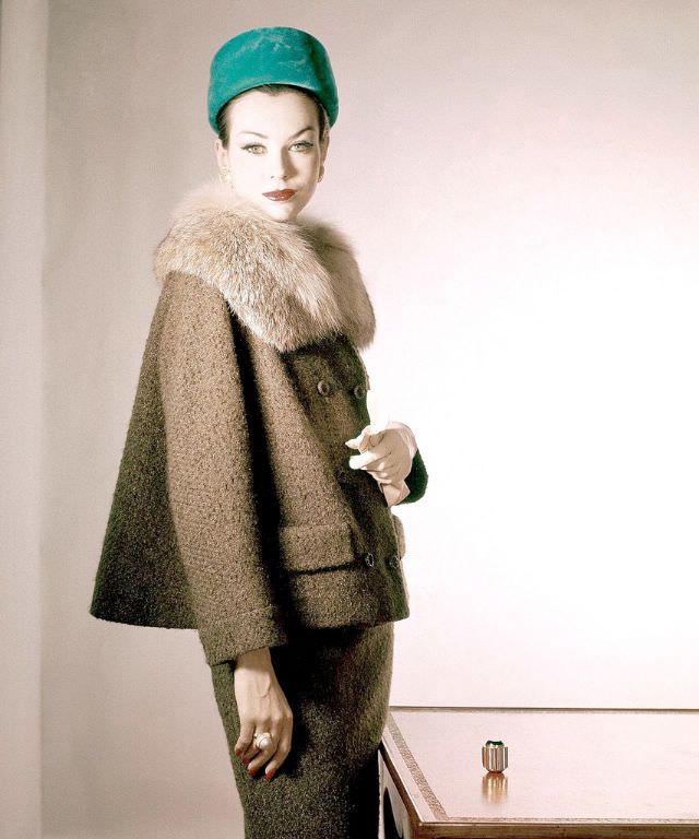 Model in tobacco tweed suit with fur collar by Handelman & Raiffe and emerald green velvet pill box, Vogue, October 1, 1959