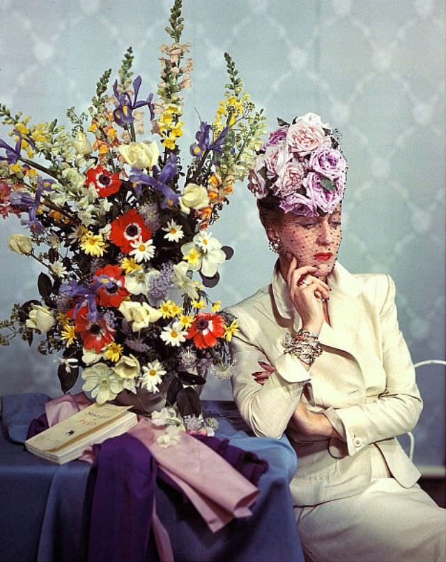 Mrs. John (Babs) Rawlings, Vogue's fashion editor, wearing a hat of roses piled on a high toque base from Vogue, 1945