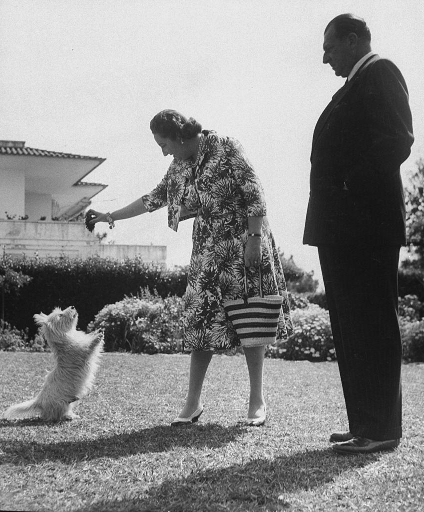 Don Juan (R) and his wife Dona Maria Mercedes playing with his West Highland White terrier.