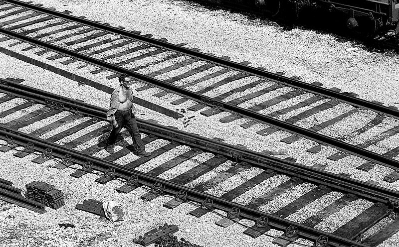 A man passing by the train tracks, in the Zona Franca near the cargo port of Barcelona, 1977.