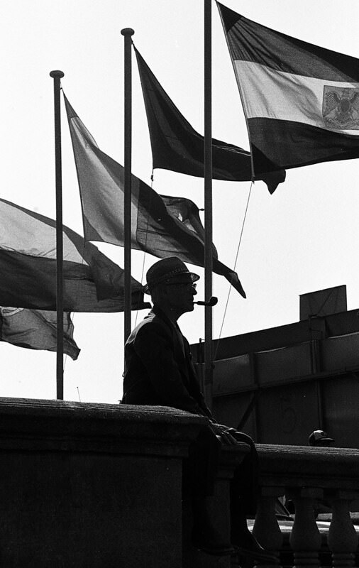 Man under the flags of the exhibition fair, 1976.