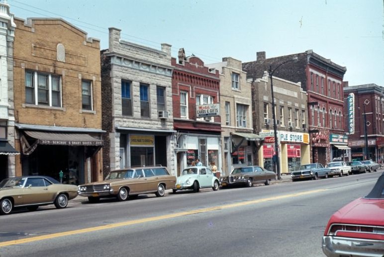 Two- and three-story buildings along the north side of West Chicago Avenue, with businesses on the ground floor and apartments above, 1970