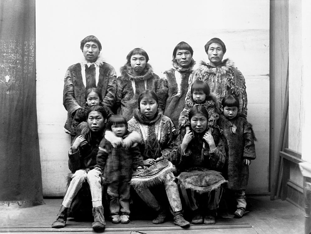 An Eskimo group of men, women, and children dressed in fur coats in Port Clarence, Alaska in 1894.