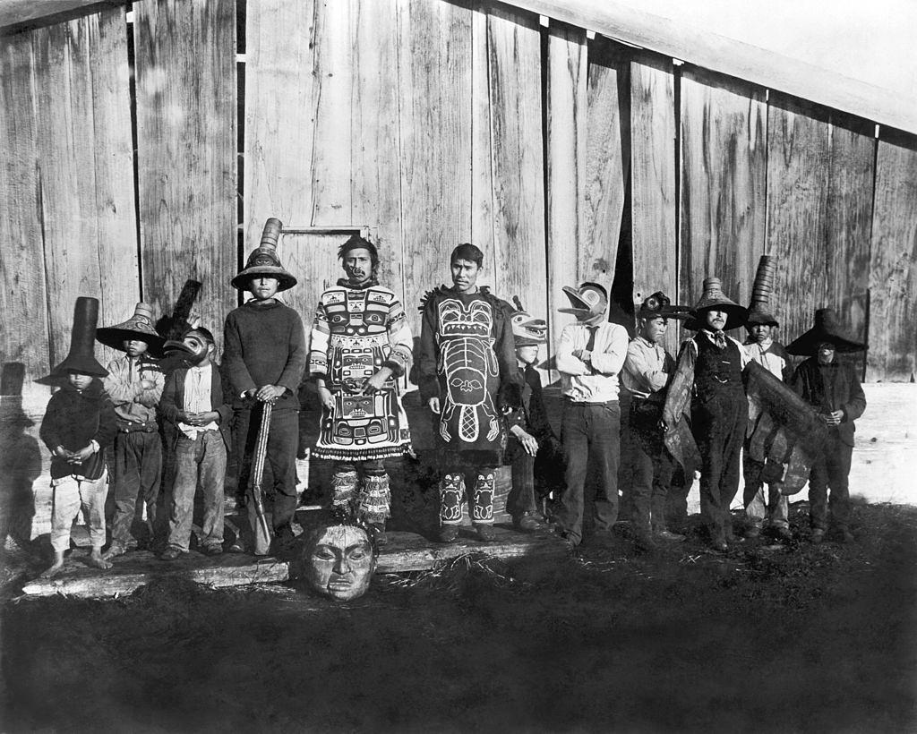 Indians in old dancing costumes in front of Chief Klart-Reech's house, Chilkat, Alaska, 1895.