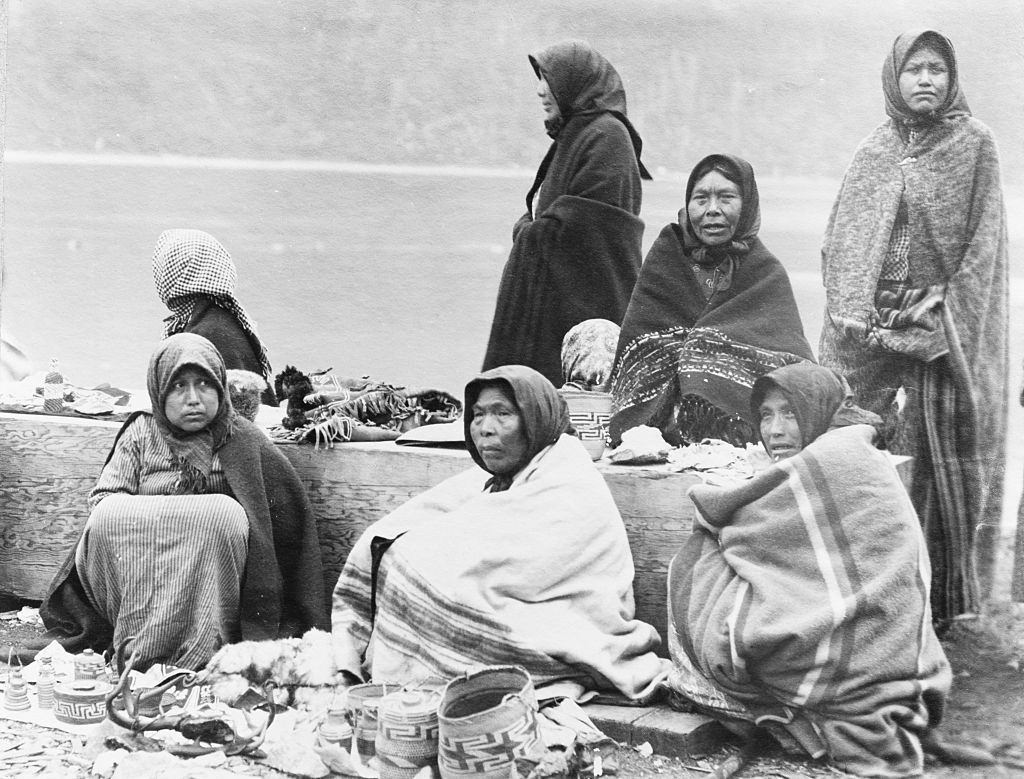 Tlingit women selling baskets and other small items, at the Treadwell Mine site, for tourists arriving in Alaska by steamship, January 1890.