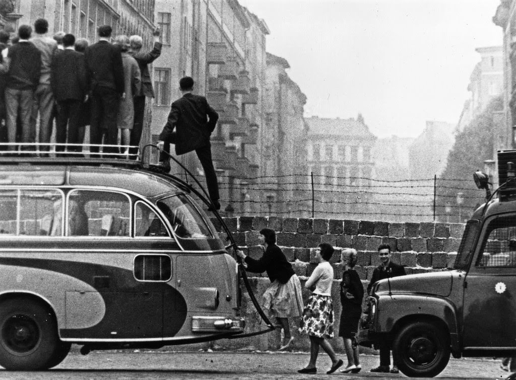 Sightseers climb onto a bus to look at the newly-built Berlin Wall.