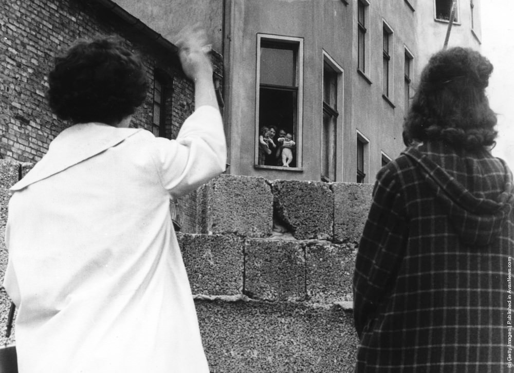 Two mothers can only wave to their children and grandchildren in the Soviet sector of Berlin from across the Berlin wall, 1961.