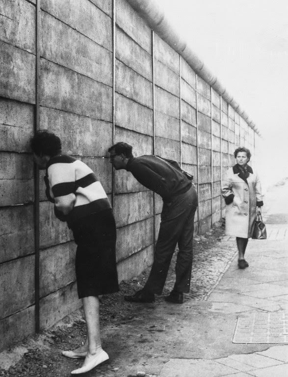West Berliners peering through the Berlin Wall into the Eastern sector near Check Point Charlie.