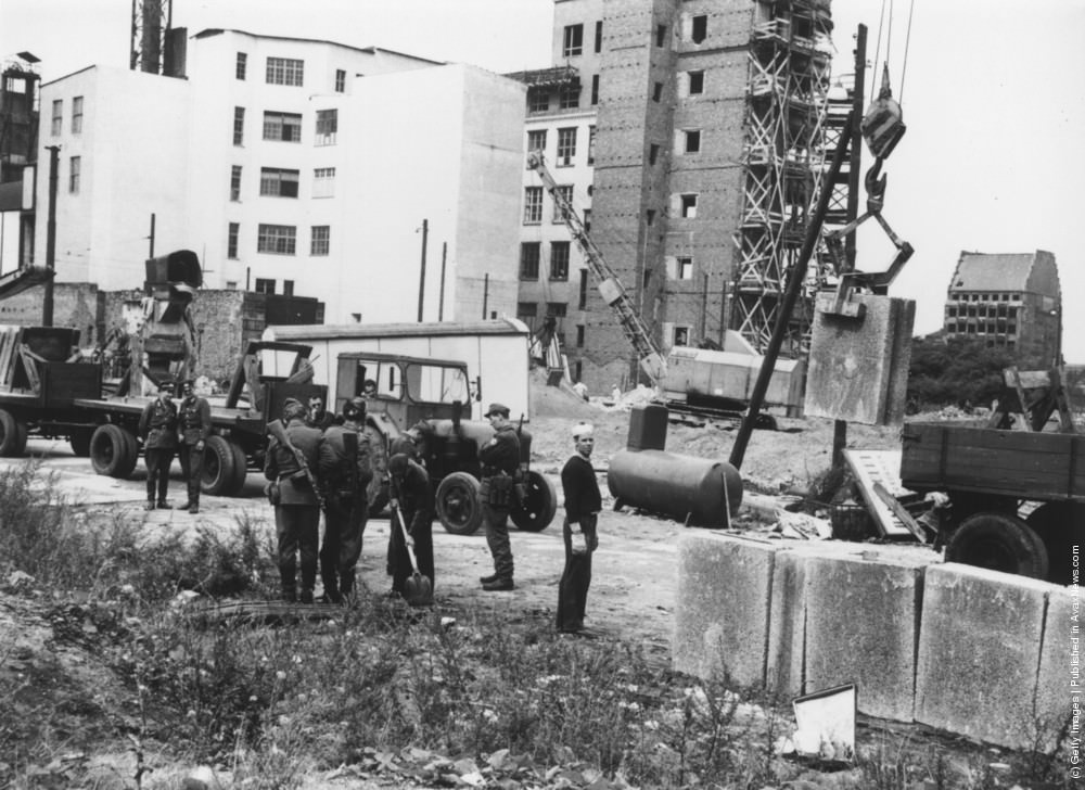 East German military personnel supervising construction of the Berlin Wall, August 1961.