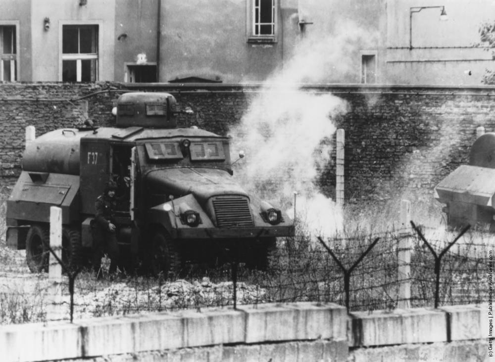 A tear gas grenade explodes next to an East German armoured car during riots on the first anniversary of the building of the Berlin Wall, circa 1960.