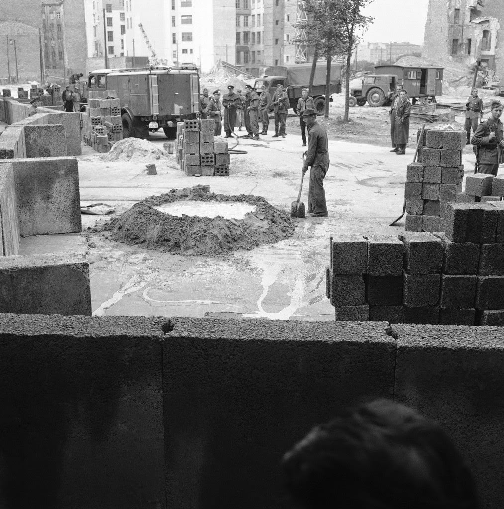Workers protected by East German police mix concrete to build walls along the sector dividing East and West Berlin August 18, 1961.