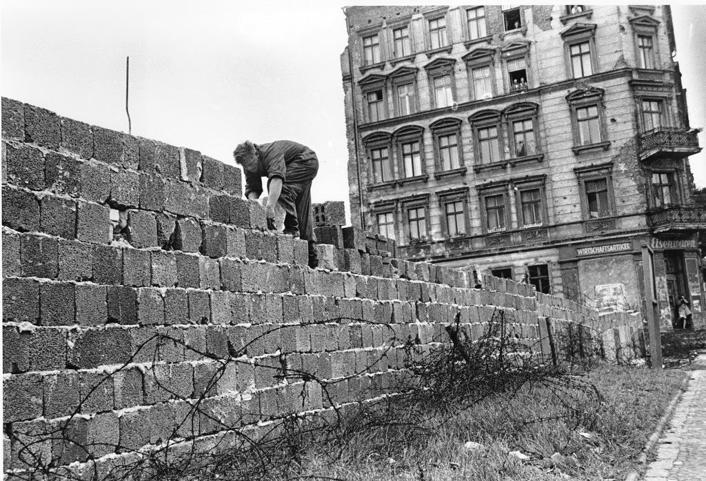 An East Berlin policeman puts bricks in place as the Berlin Wall is heightened to 15 feet, 5 m, separating East and West Berlin, Germany, on Sept. 9, 1961.