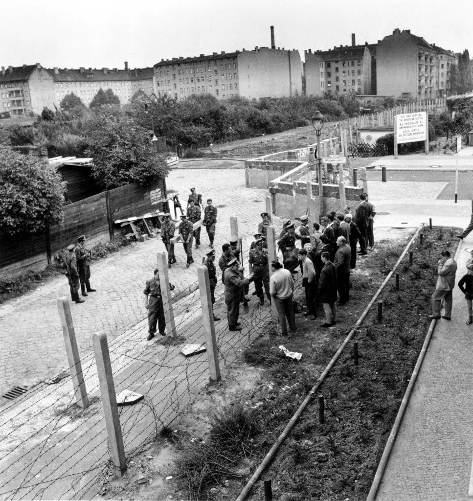West Berliners, at right, talk with East Berlin policemen through the barbed wire fence at the border in Germany in Sept. 1961.