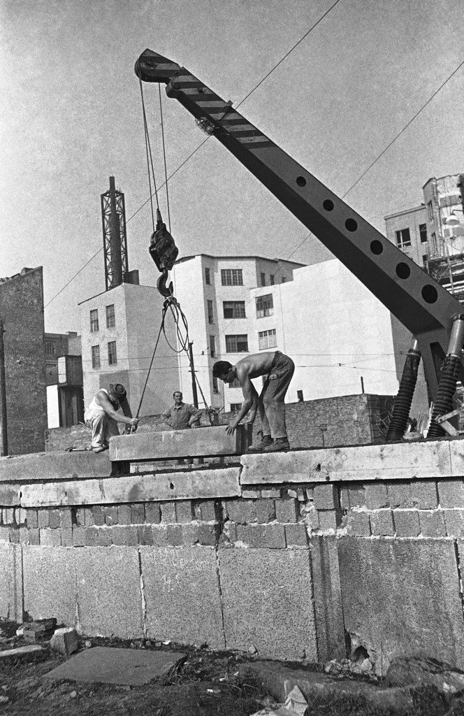 East Berliners use a crane to place concrete glass on wall along border between East and West Berlin Sept. 28, 1961. View of Zimmerstrasse near the Friedrichstrasse crossing point in the divided city.