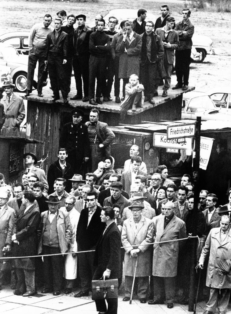 West Berliners watch the incidents at the U.S. Army checkpoint at the Friedrichstrasse where an American car and two sightseeing buses were barred entry by Communist East Berlin police, in Berlin on Oct. 25, 1961.