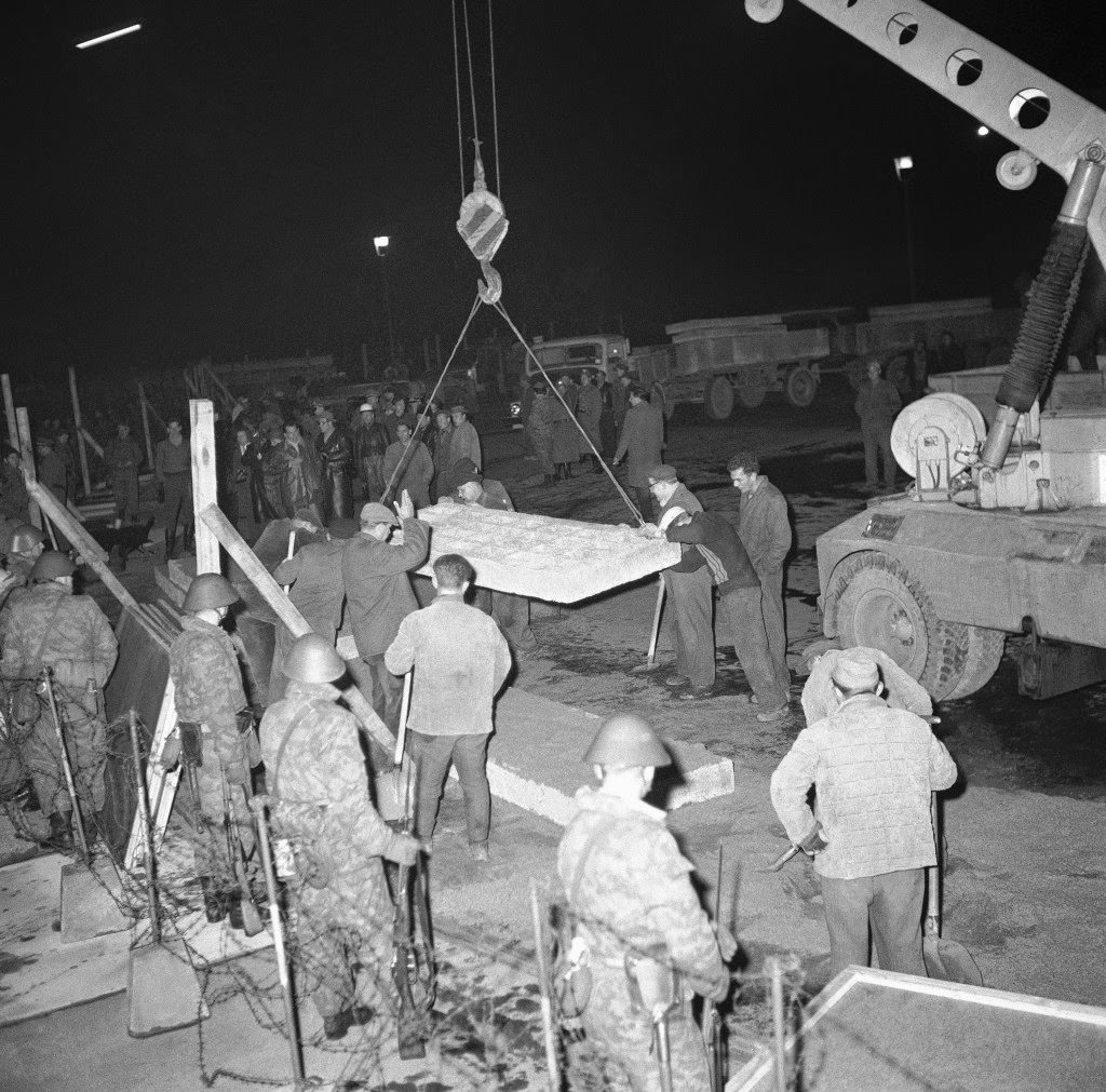 East German workmen guide crane lowering concrete block into position to make wall in front of Brandenburg Gate in East Berlin on Nov. 19, 1961.