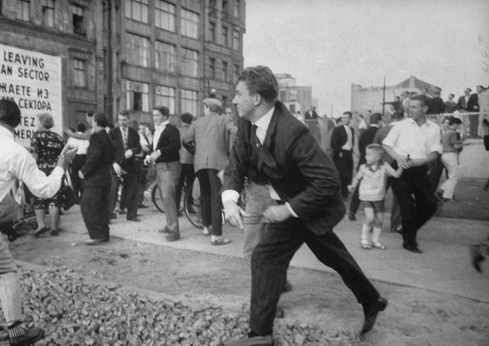 West Berliners, angered by taunts from East Berlin Police, throw rocks in August 1961.