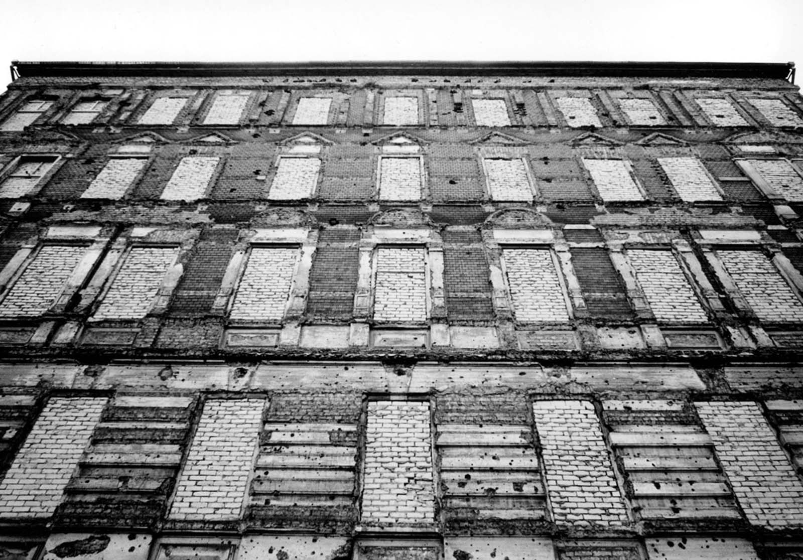 After East Germans jumped to freedom in the West, the windows of this building on the eastern side of the wall were bricked over. The building was later demolished, 1962.