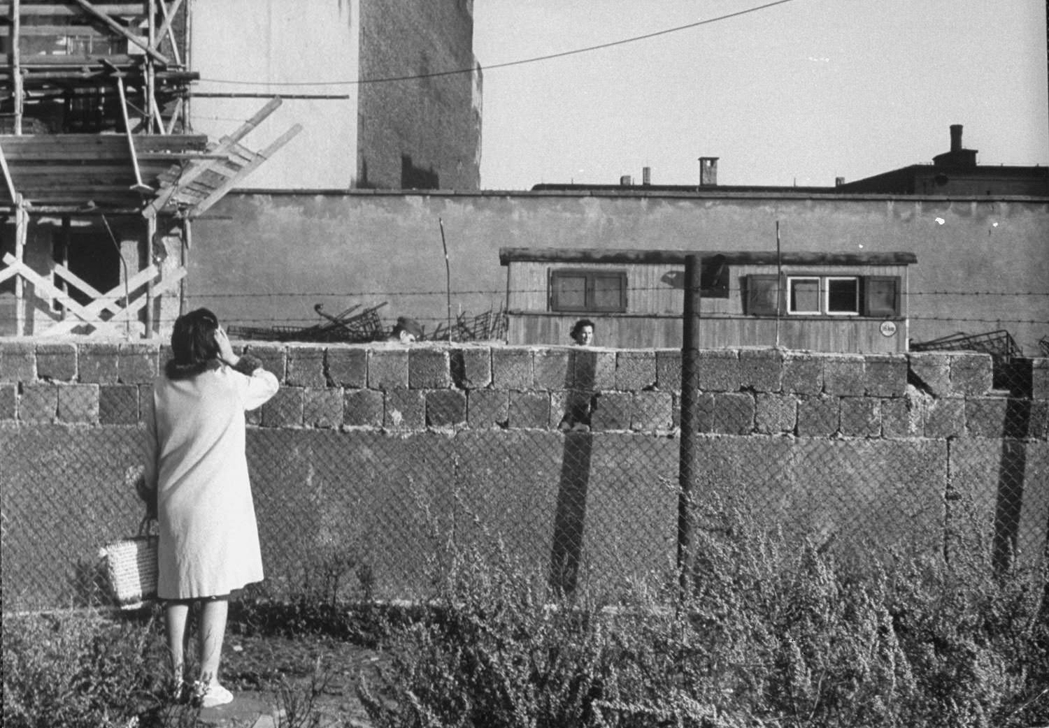 A woman, foreground, who had escaped to West Berlin, speaks to her mother — who is still in East Berlin — in August 1961.