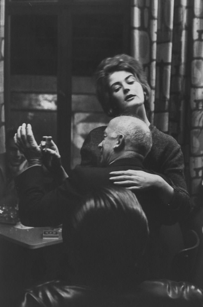 A couple enjoys a West Berlin bar as the Wall looms in the near distance in 1961