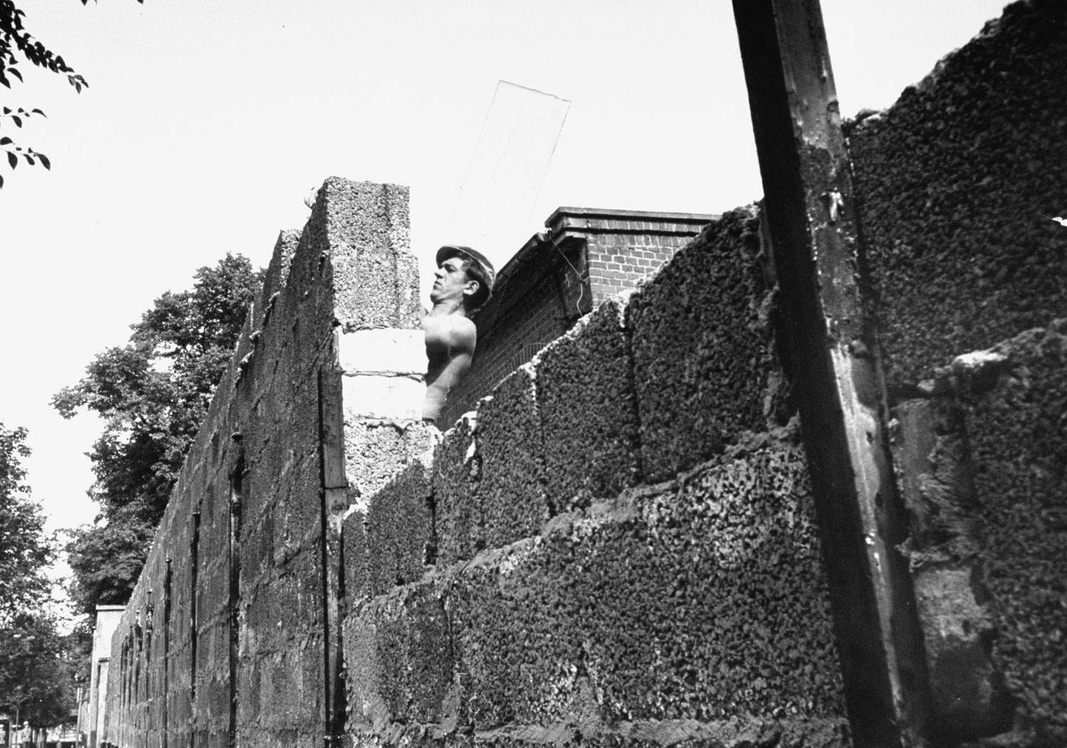 An East German mason builds up a fresh portion of the Berlin Wall in August 1961.